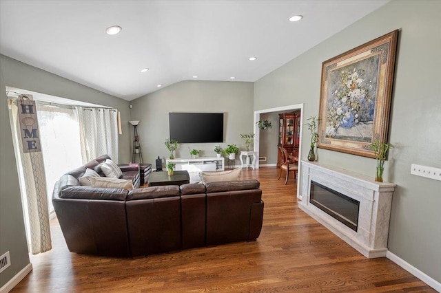 living room with a fireplace, wood-type flooring, and lofted ceiling