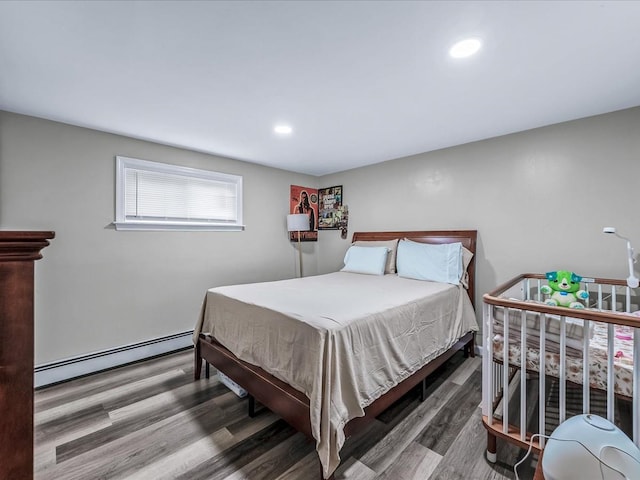 bedroom featuring baseboard heating and hardwood / wood-style flooring