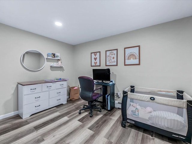 office area featuring wood-type flooring and a baseboard radiator