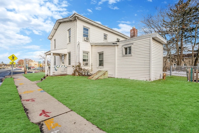 rear view of property with cooling unit and a lawn