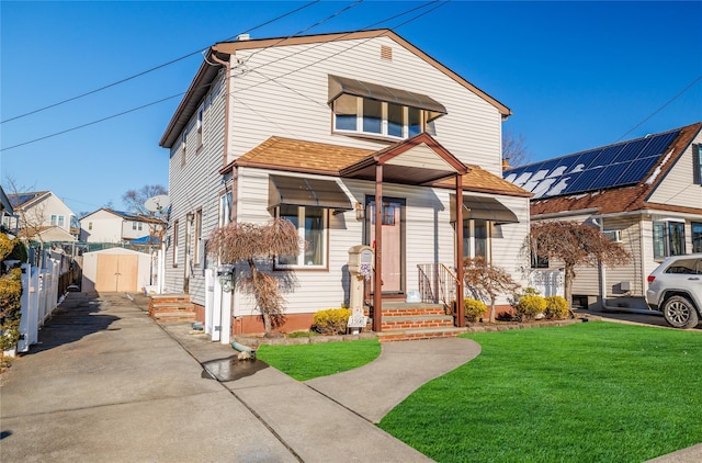 view of front of house featuring a front lawn, a shed, and solar panels