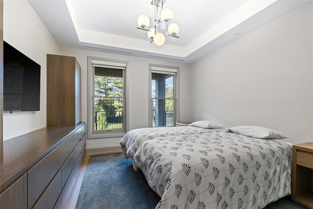 bedroom with a notable chandelier, dark hardwood / wood-style flooring, and a raised ceiling