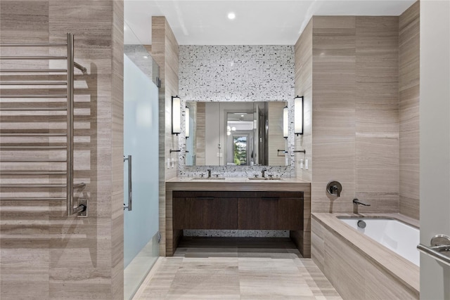 bathroom featuring tile patterned floors, vanity, separate shower and tub, and tile walls