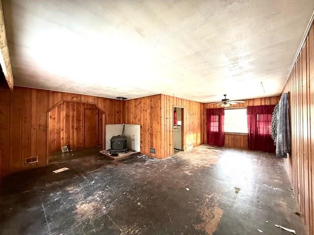 miscellaneous room featuring a wood stove and ceiling fan