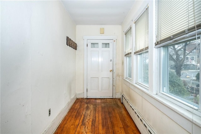 doorway with a baseboard radiator and dark hardwood / wood-style floors