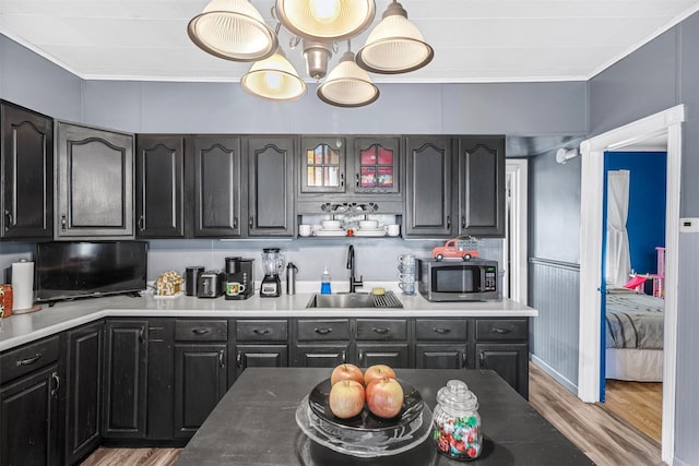 kitchen featuring sink, light hardwood / wood-style floors, and ornamental molding