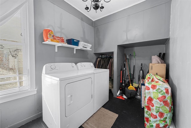 clothes washing area with independent washer and dryer, crown molding, and an inviting chandelier