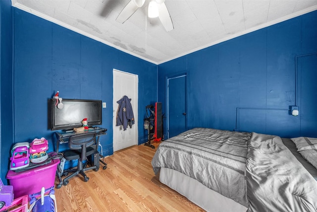 bedroom with ceiling fan, crown molding, and hardwood / wood-style flooring