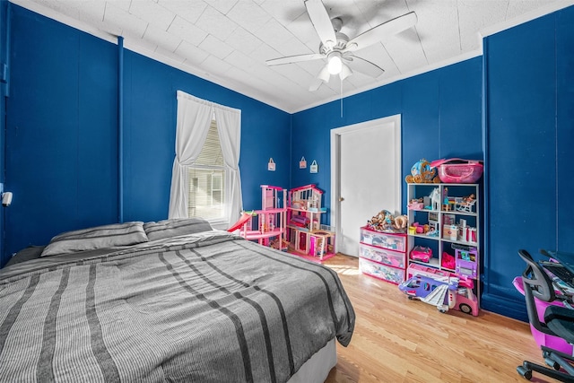 bedroom with wood-type flooring, ceiling fan, and crown molding