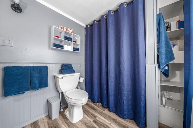 bathroom featuring hardwood / wood-style flooring, toilet, and ornamental molding