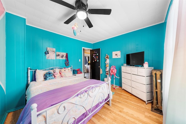 bedroom with light hardwood / wood-style floors, ceiling fan, and crown molding