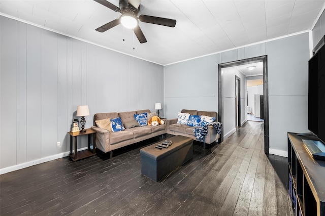 living room featuring dark wood-type flooring, ceiling fan, and crown molding