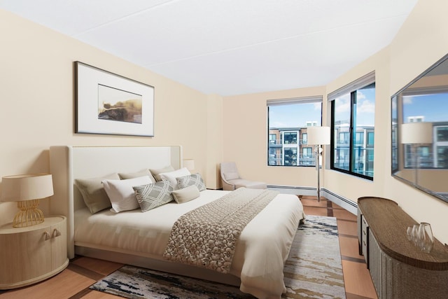 bedroom featuring light wood-type flooring and a baseboard heating unit