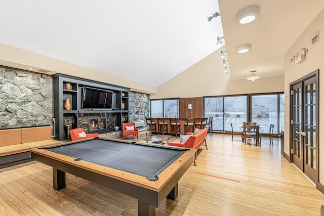 rec room with a fireplace, light hardwood / wood-style floors, high vaulted ceiling, and billiards