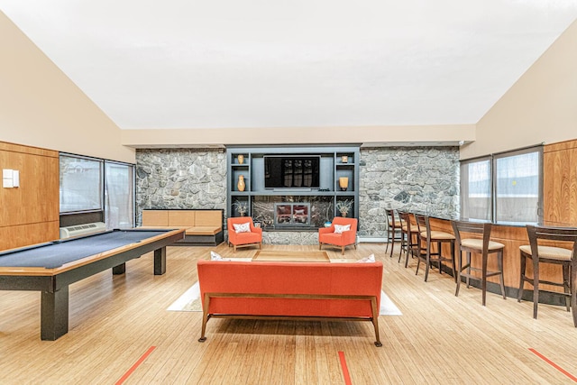 recreation room featuring hardwood / wood-style floors, high vaulted ceiling, a stone fireplace, and pool table