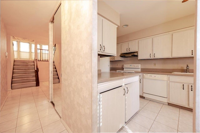 kitchen featuring sink, white appliances, white cabinetry, and light tile patterned floors