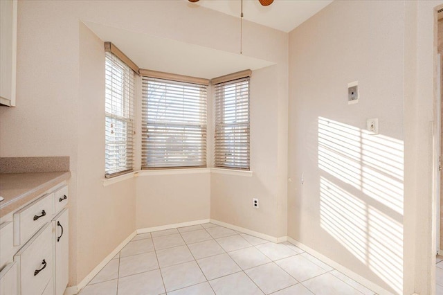 unfurnished dining area with light tile patterned flooring and ceiling fan