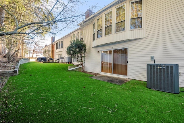 rear view of house featuring a lawn and cooling unit