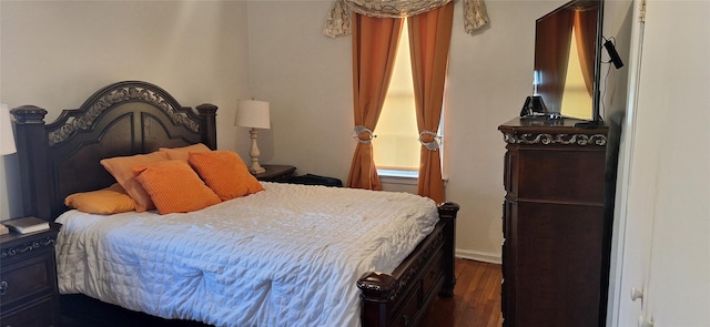 bedroom with dark hardwood / wood-style floors