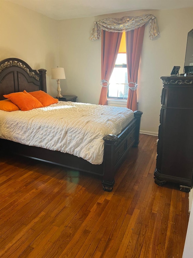 bedroom with dark hardwood / wood-style flooring