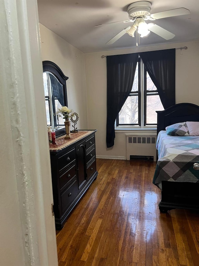 bedroom featuring radiator heating unit, ceiling fan, and dark wood-type flooring