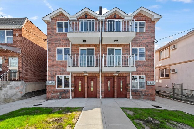 view of property with a wall mounted AC and a balcony