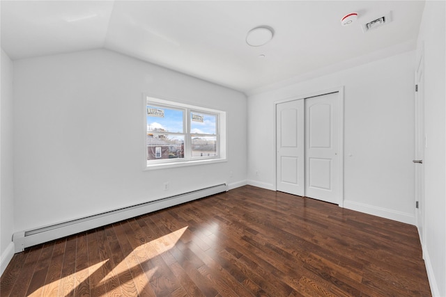 unfurnished bedroom with a baseboard radiator, a closet, lofted ceiling, and dark hardwood / wood-style floors