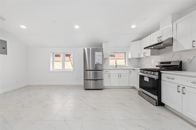 kitchen with lofted ceiling, white cabinetry, stainless steel appliances, and electric panel