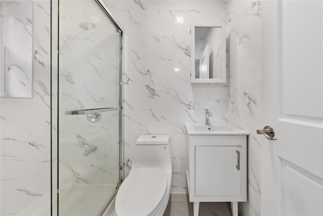 bathroom with vanity, toilet, a shower with shower door, and tile walls