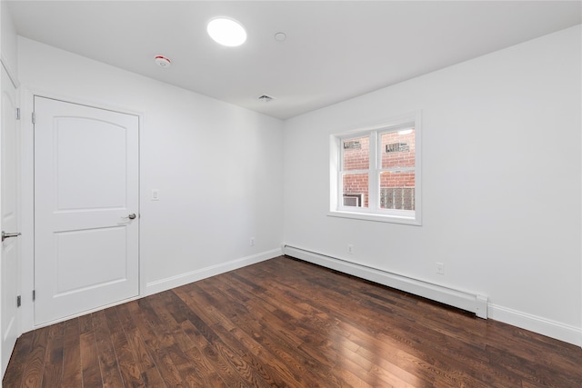 spare room with dark hardwood / wood-style floors and a baseboard radiator