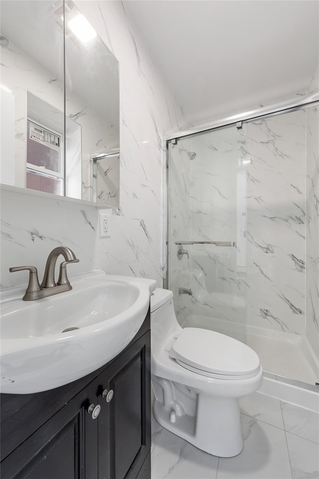 bathroom with vanity, toilet, tile walls, and a shower with shower door