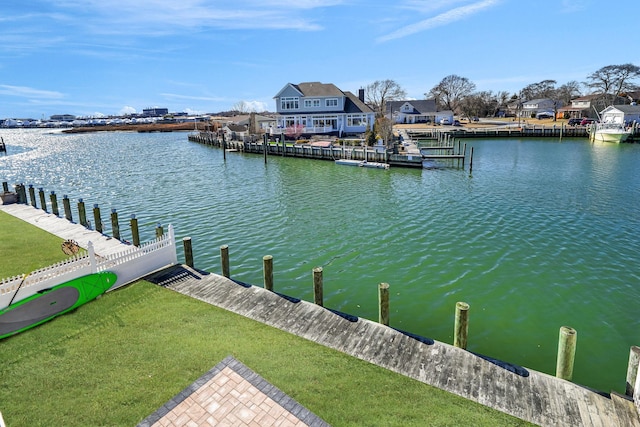 dock area featuring a water view, a residential view, and a yard