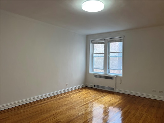 unfurnished room featuring light wood-type flooring and radiator