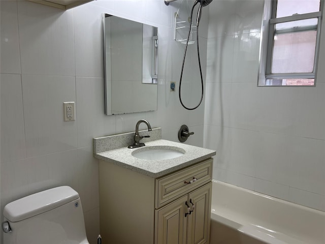 full bathroom featuring vanity, toilet, tile walls, and shower / washtub combination