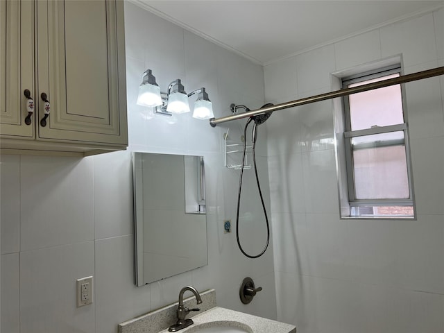 bathroom with vanity, tiled shower, and a wealth of natural light