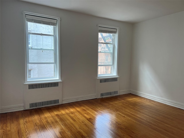 unfurnished room featuring wood-type flooring and radiator