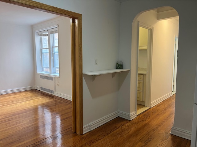 hallway with light wood-type flooring and radiator