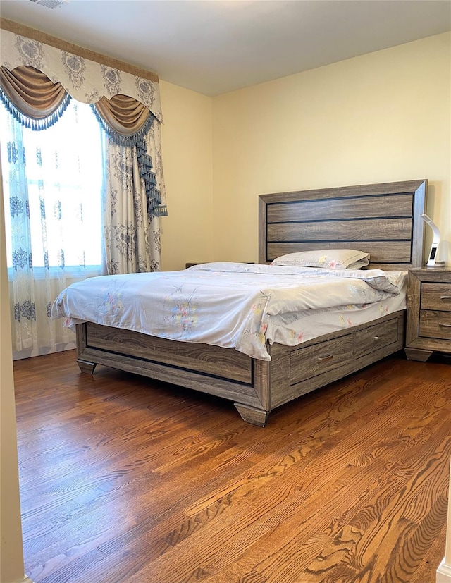 bedroom with dark hardwood / wood-style floors