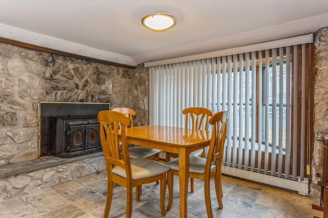 dining space featuring a baseboard heating unit and a wood stove