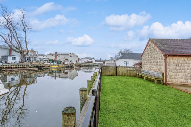 view of dock with a water view and a lawn