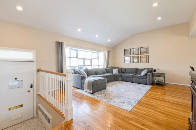 living room featuring light hardwood / wood-style floors and vaulted ceiling