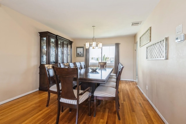 dining room featuring hardwood / wood-style floors and a chandelier