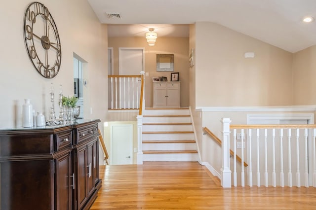 corridor with vaulted ceiling and light hardwood / wood-style flooring