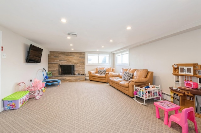 rec room featuring carpet flooring, a stone fireplace, and baseboard heating