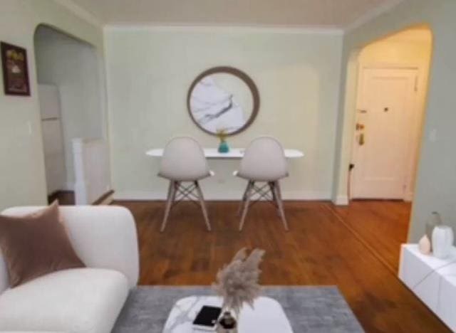 living area featuring hardwood / wood-style floors and crown molding