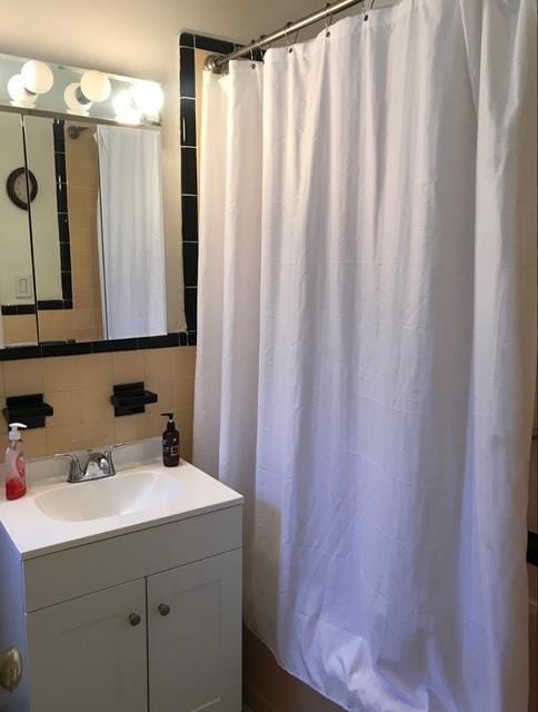 bathroom featuring vanity and tasteful backsplash