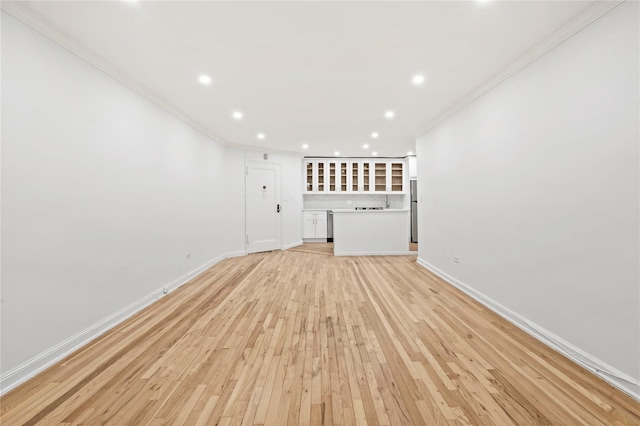 interior space featuring crown molding and light hardwood / wood-style flooring