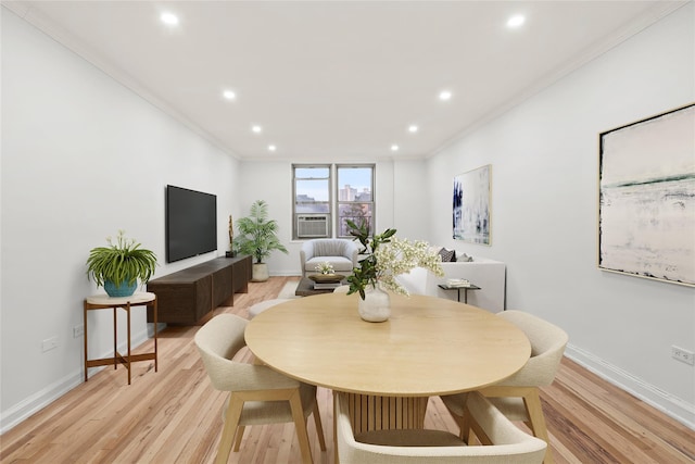 dining space featuring crown molding and light hardwood / wood-style flooring