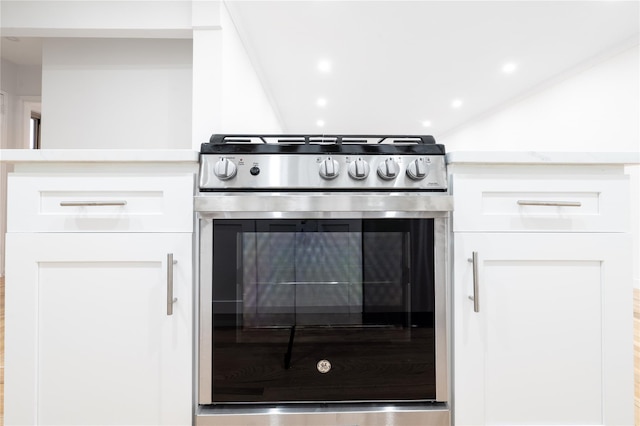 kitchen with gas stove and white cabinets