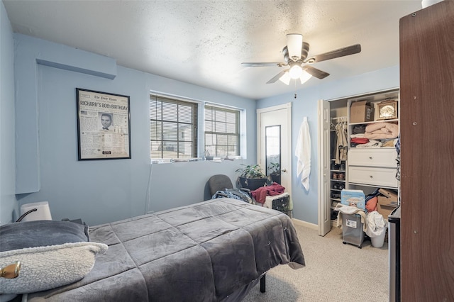 bedroom with baseboards, light colored carpet, a textured ceiling, and a ceiling fan